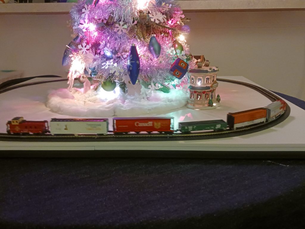 N-Scale train passing in front of the tree.