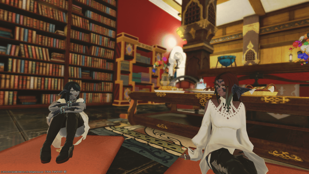 Laureine and her cousin, Lizicus, sitting in front of a fireplace in Final Fantasy XIV.