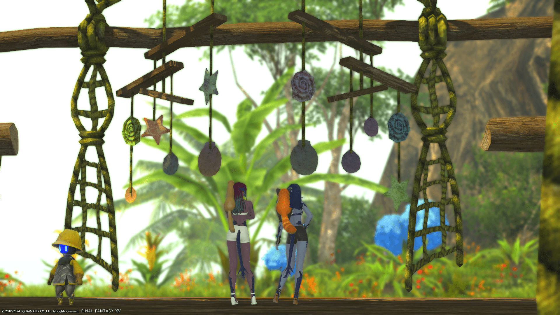 Lizicus & Laureine under a wooden tropical shelter with nets and seashells hanging above them.