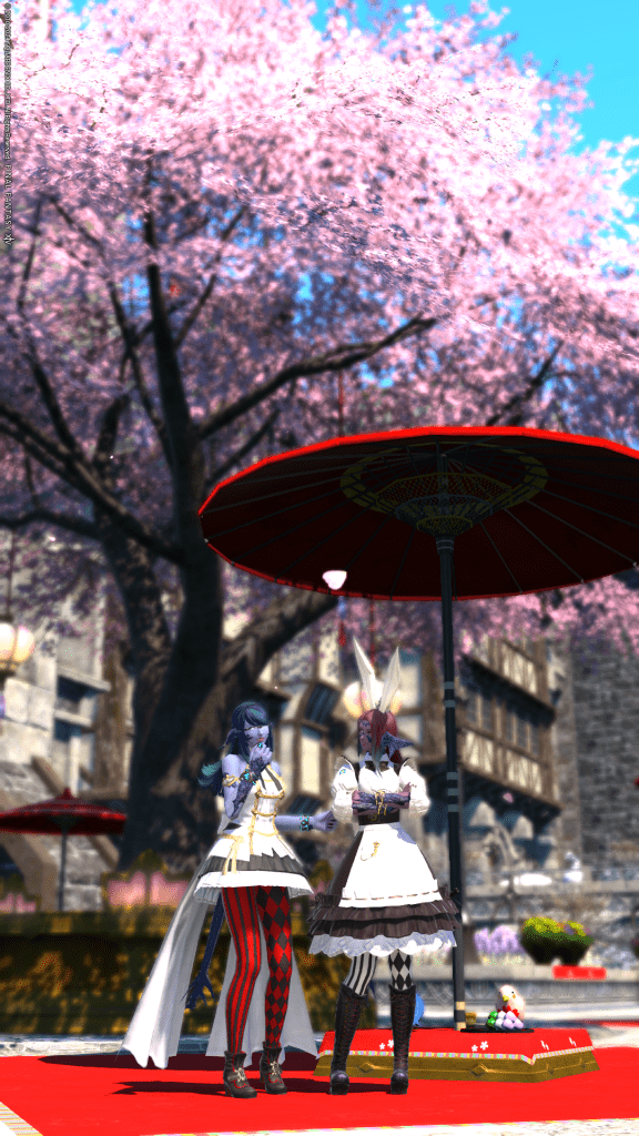 Laureine and Lizicus dressed up for the Little Ladies' Day & Hatching-Tide event. Standing in front of Little Ladies' Day decor showing the cherry blossom tree in the background.